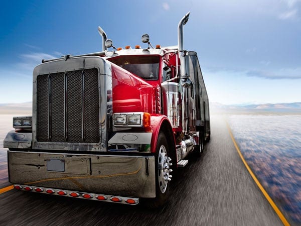 Red 18-wheeler Truck Driving On A Rural Highway Stock Photo
