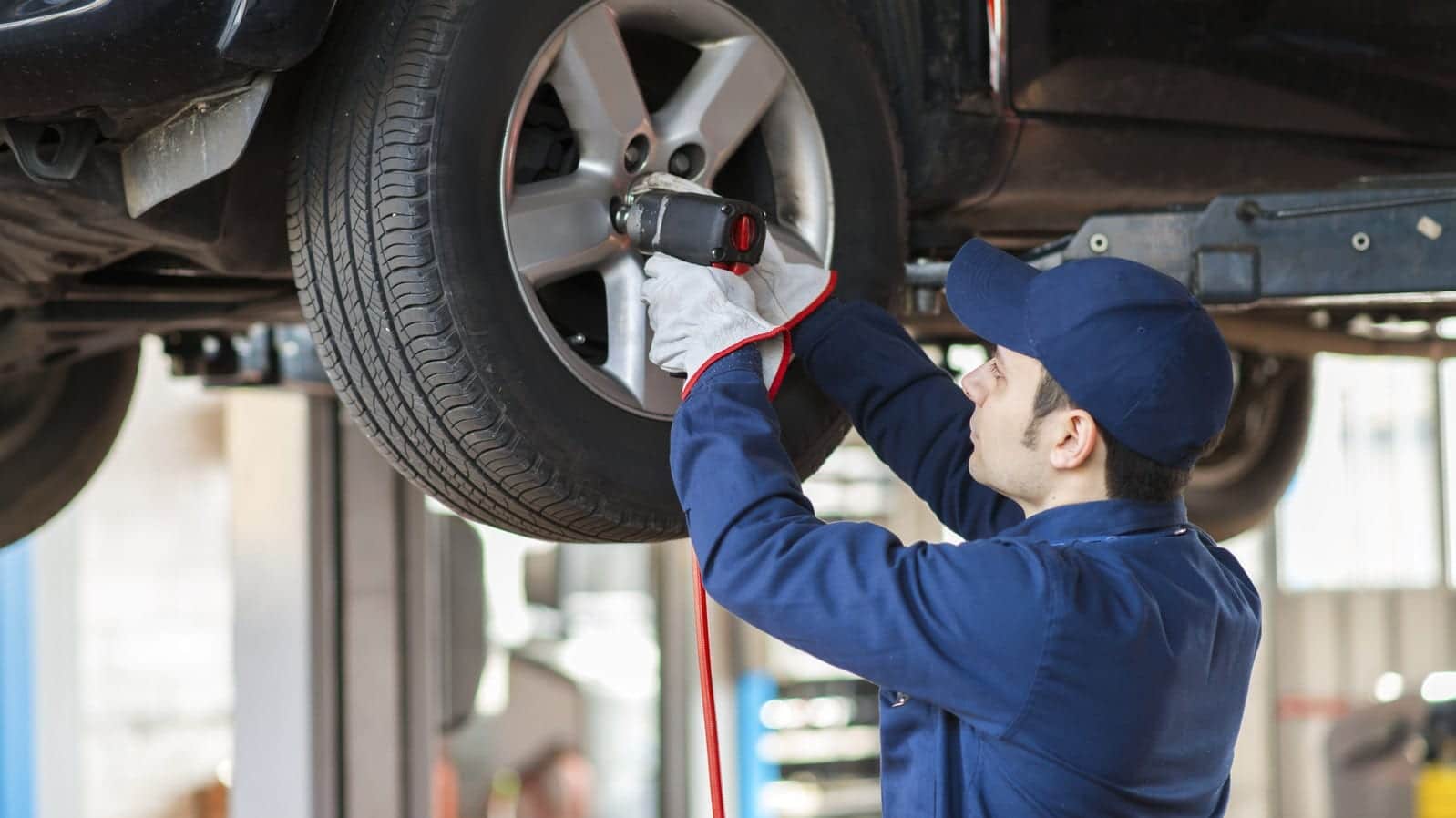 Mechanic Changing A Tire In An Auto Body Shop Stock Photo