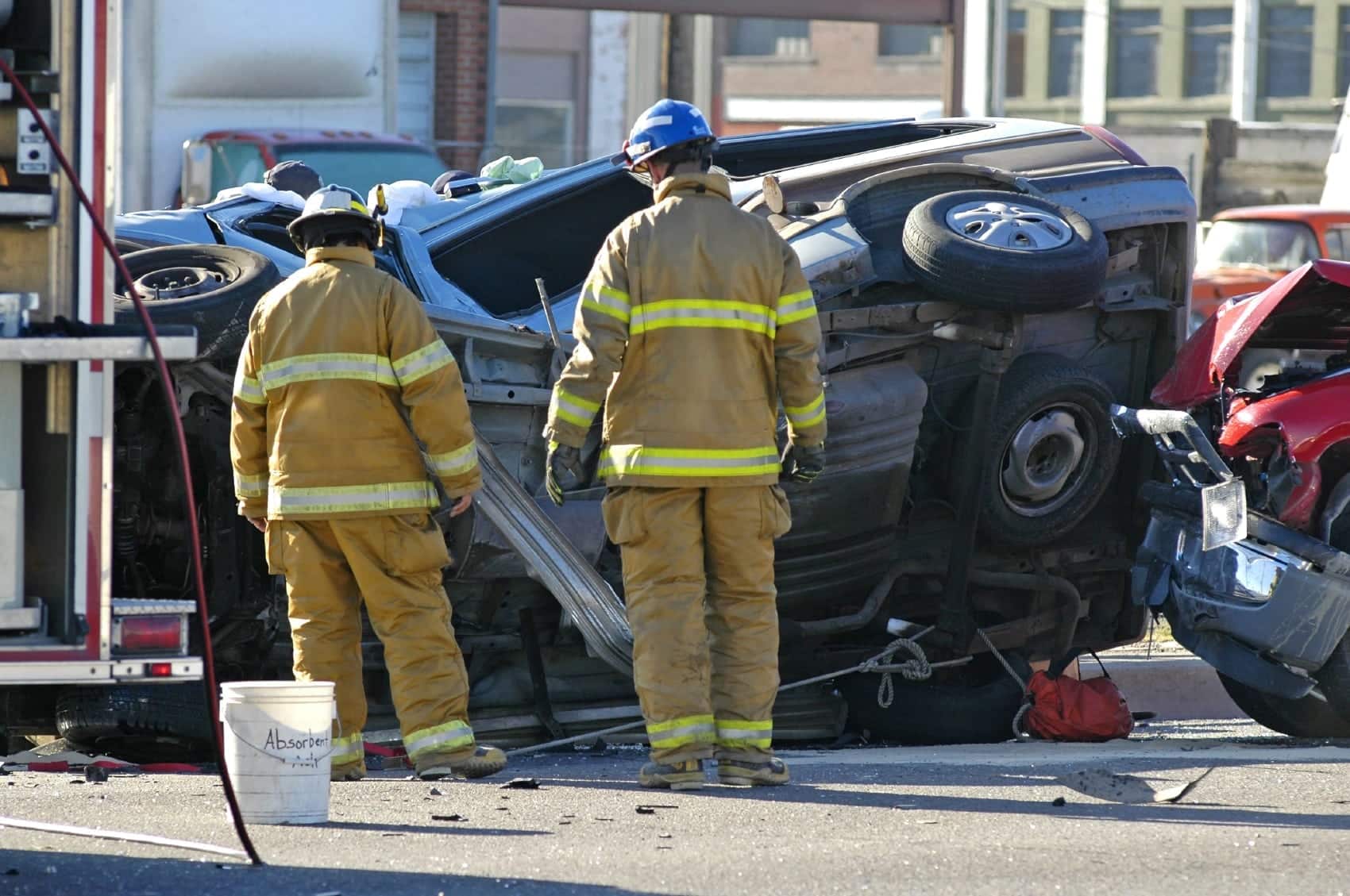 Firefighters Examining Rollover Car Accident Stock Photo