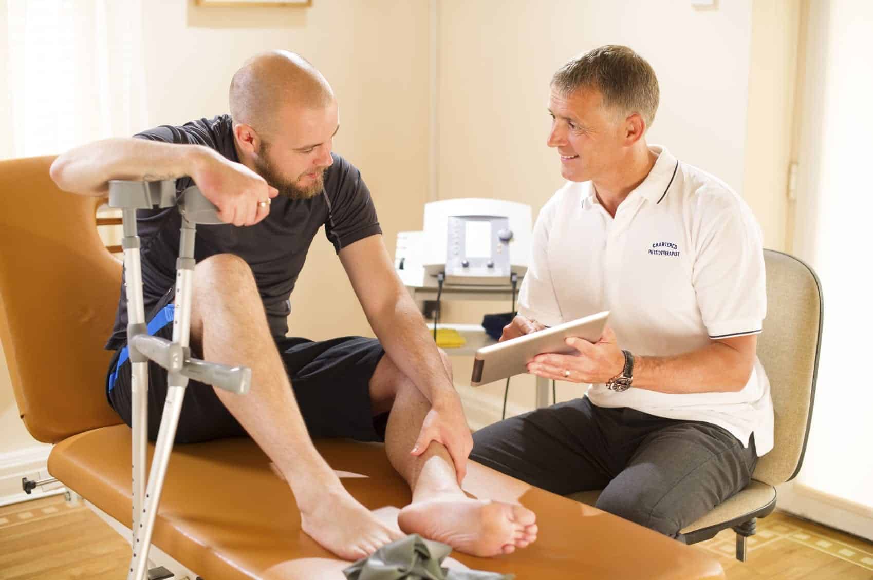 Physician Meeting Privately With An Injured Man Stock Photo