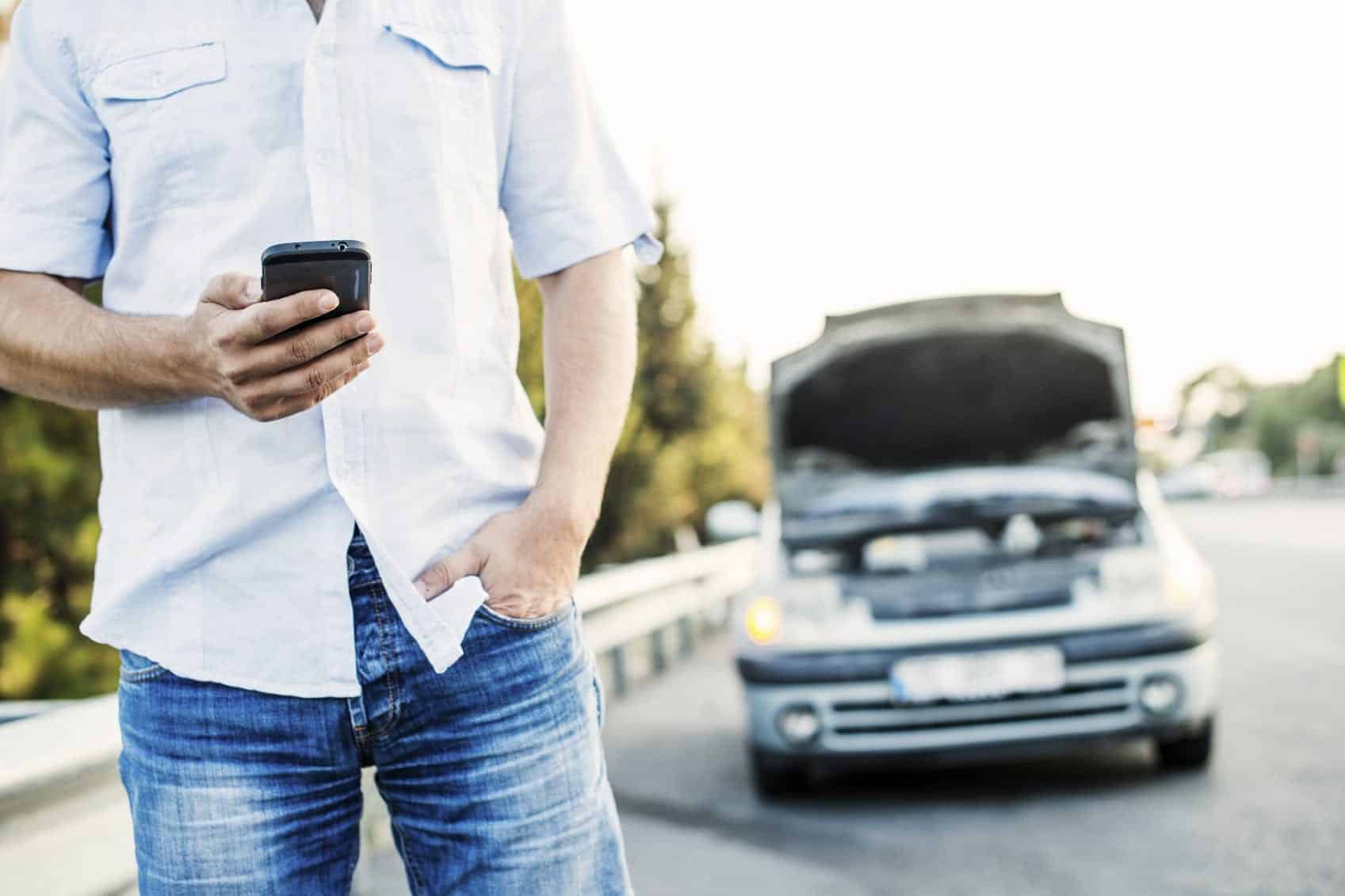 Man Calling Tow Truck On Shoulder Of The Highway Stock Photo