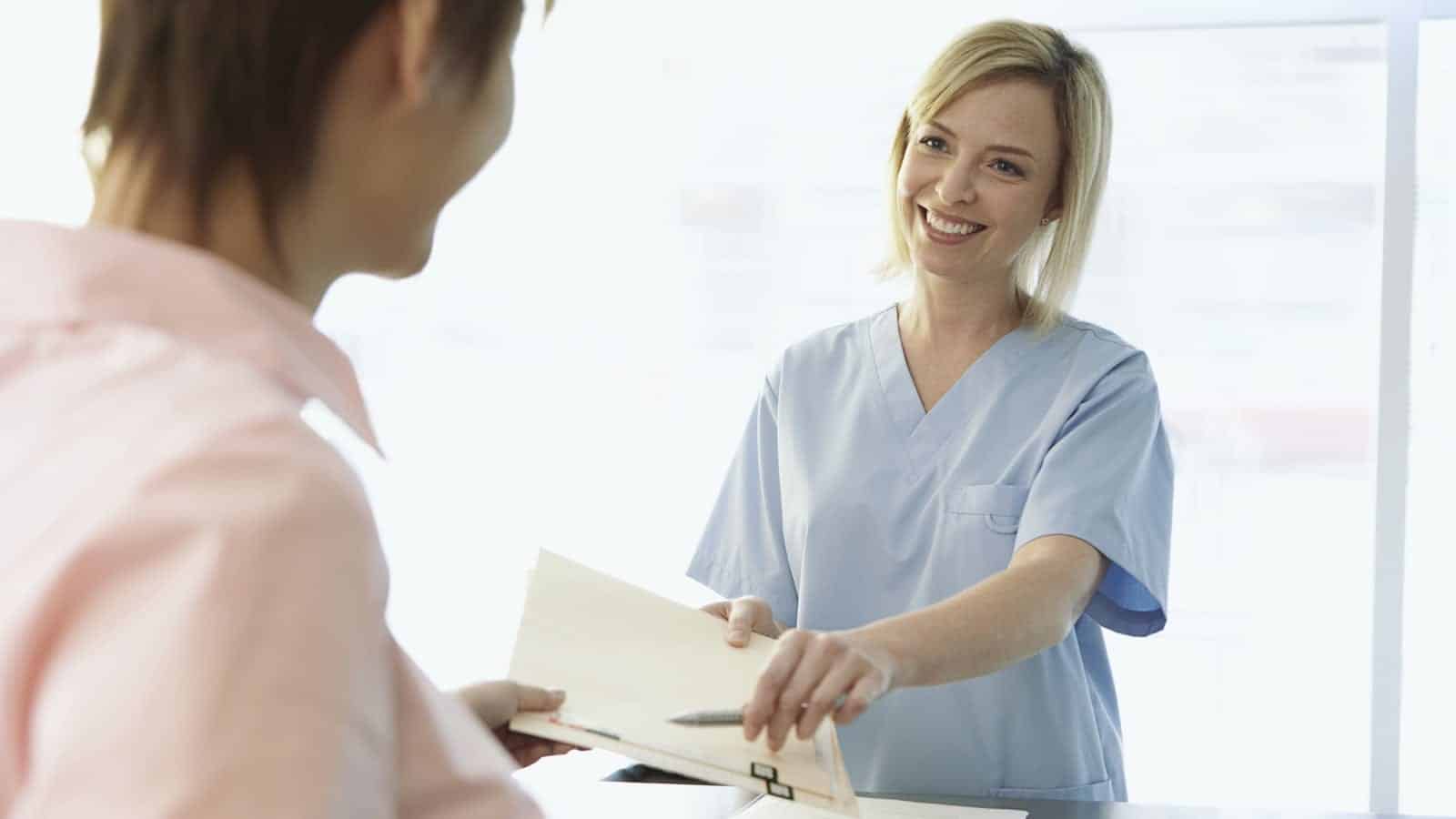 Female Nurse Speaking With Female Patient In Doctor's Office