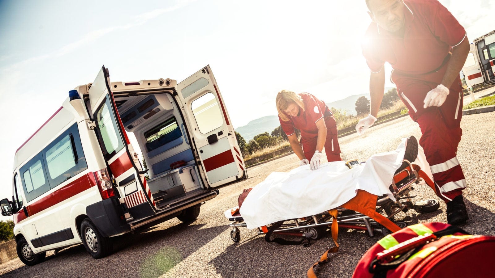 Paramedics Loading An Injured Man Onto A Stretcher Stock Photo
