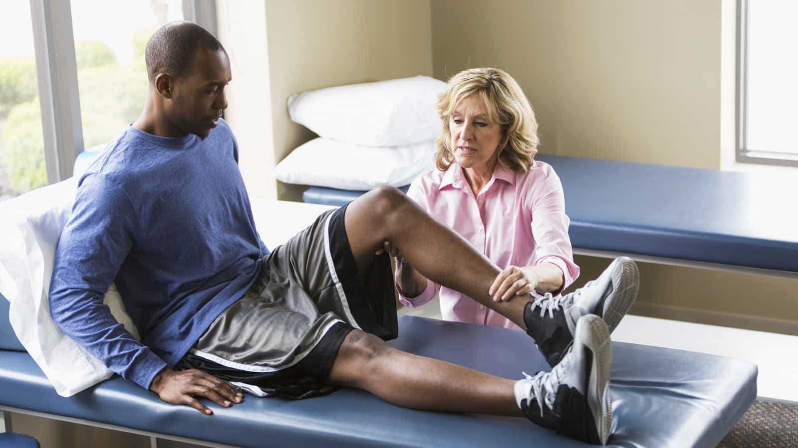 Female Physical Therapist Working With Male Patient Stock Photo