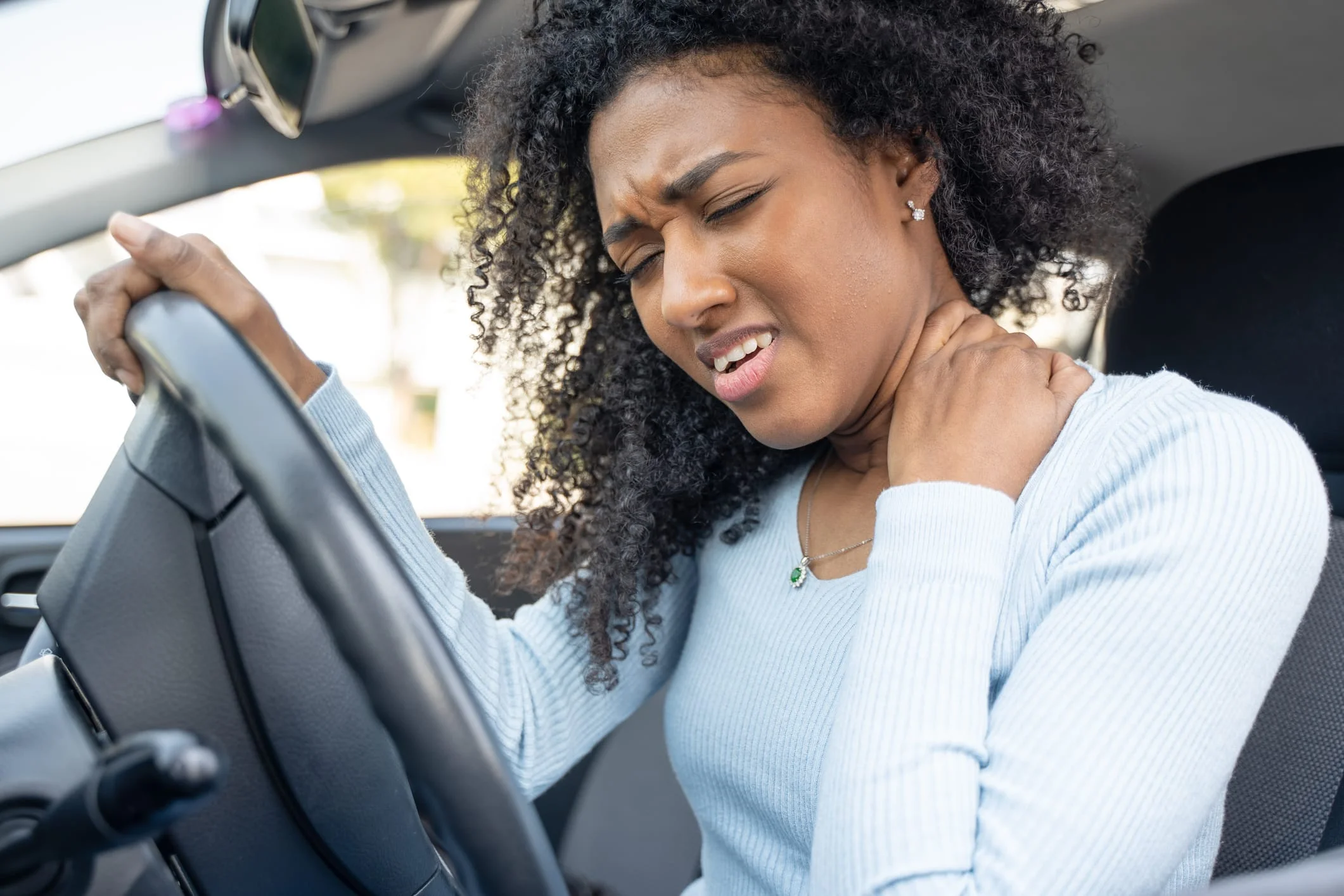 A black woman hurts her neck after a car accident One black woman in the car with neck pain