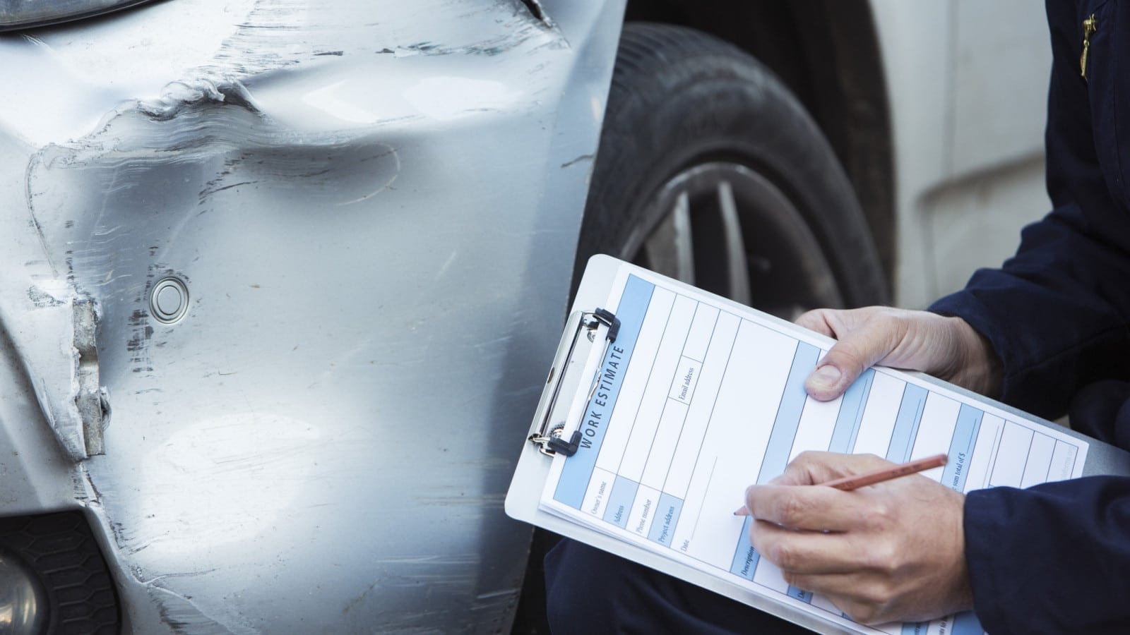 Insurance Adjuster Examining Damage To A Vehicle Stock Photo