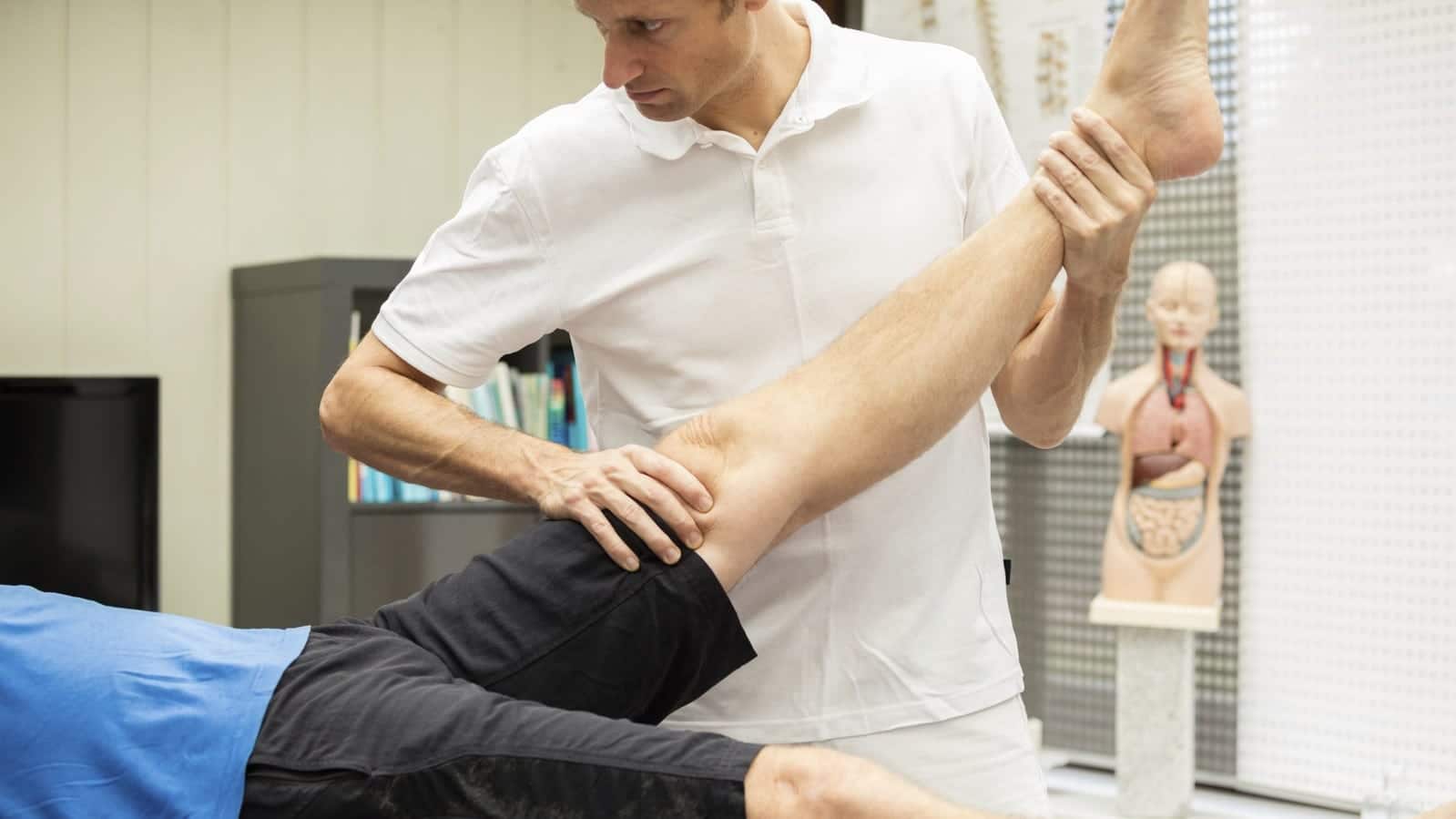 Medical Professional Examining Man's Injured Leg Stock Photo