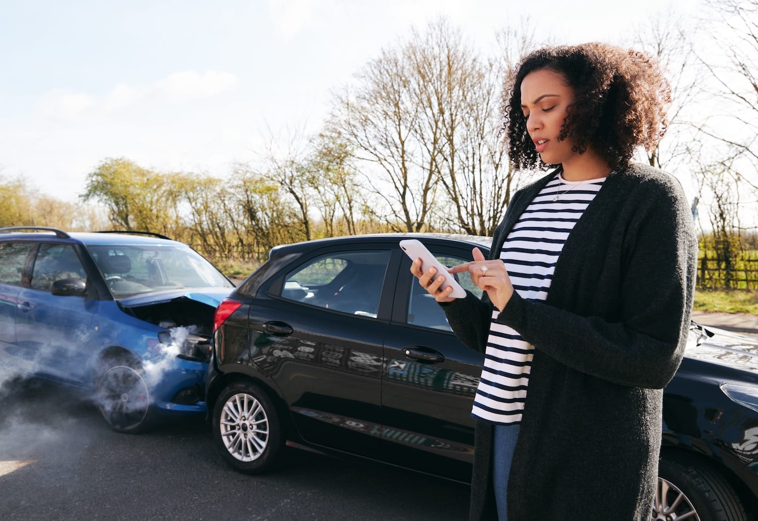 Female driver contacting her auto insurance after a car crash.