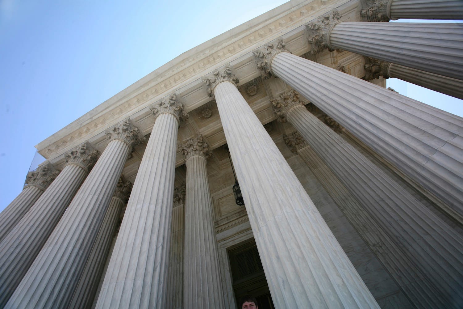 The entrance of a courthouse from a low angle on a sunny day.